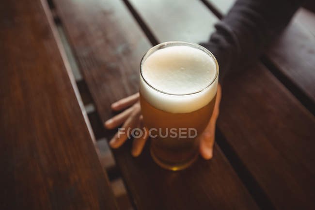 Чоловік тримає келих пива в барі — стокове фото