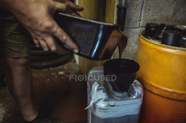 Óleo de despejo mecânico em lata na oficina — Fotografia de Stock