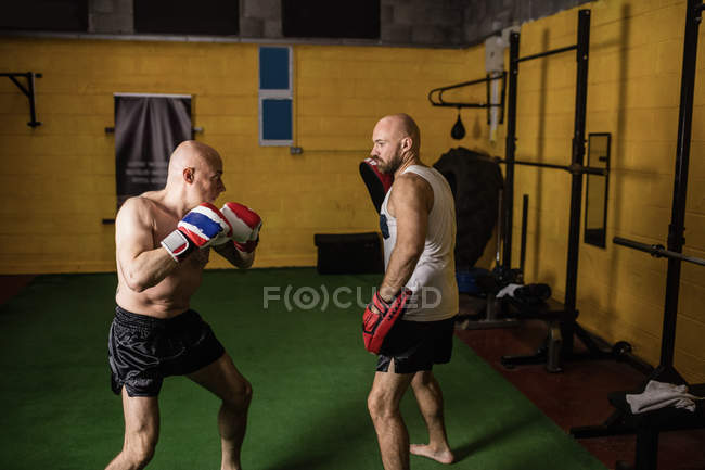 Athletic Thai boxers practicing boxing in gym — Stock Photo