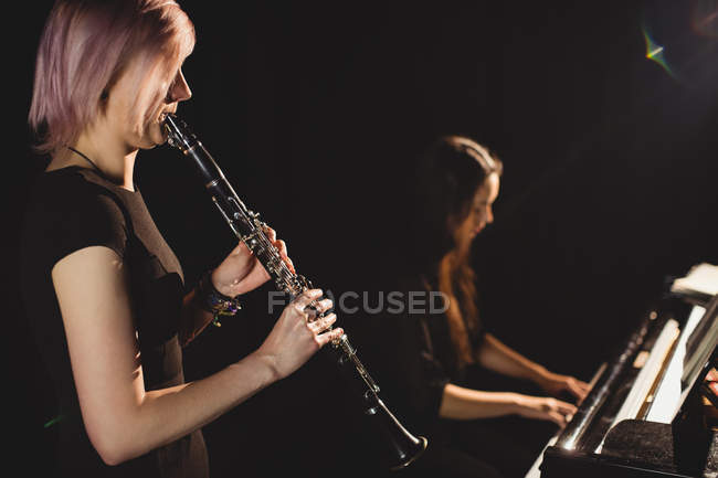 Alunos tocando clarinete e piano na escola de música — Fotografia de Stock