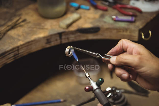 Hands of craftswoman using blow torch in workshop — Stock Photo