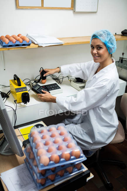 Mitarbeiterinnen untersuchen Ei auf digitalem Ei-Monitor in Eierfabrik — Stockfoto