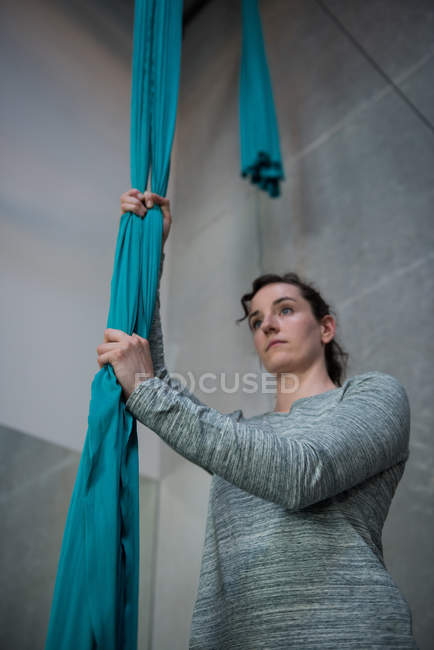 Gymnast holding fabric rope in fitness studio — Stock Photo