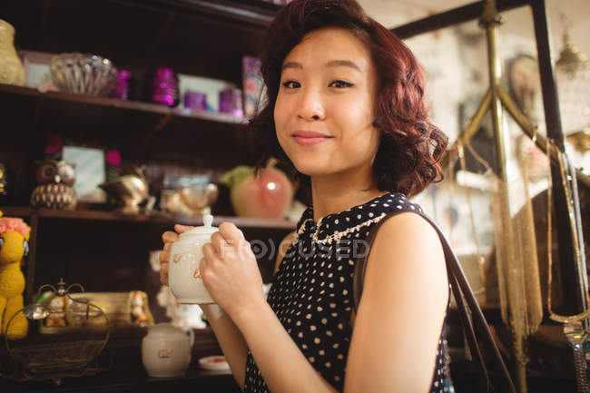 Ritratto di donna elegante che seleziona una teiera in un negozio di antiquariato — Foto stock