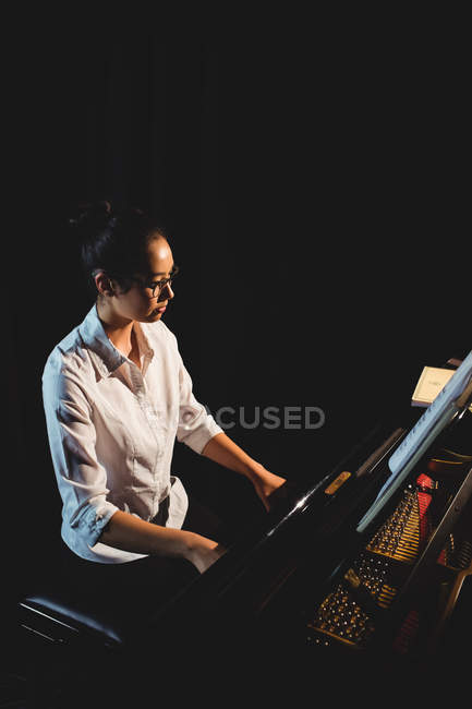 Красивая женщина играет на пианино в музыкальной студии — стоковое фото