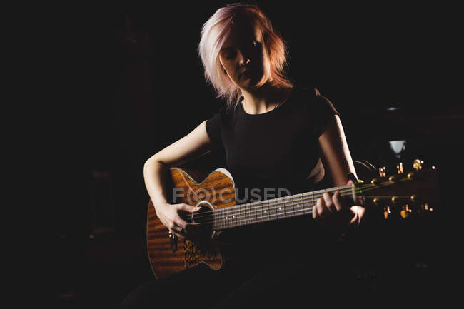 Studente donna che suona la chitarra in uno studio — Foto stock