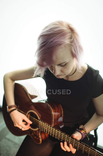 Woman playing a guitar in music school — Stock Photo