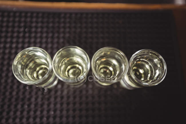 Gros plan de la tequila dans les verres de vue sur le comptoir du bar au bar — Photo de stock