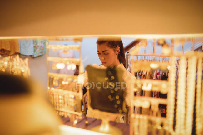 Женщина выбирает ювелирные изделия в бутик-магазине — стоковое фото