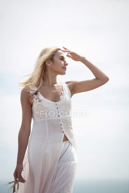 Attractive blonde woman looking away in field — Stock Photo