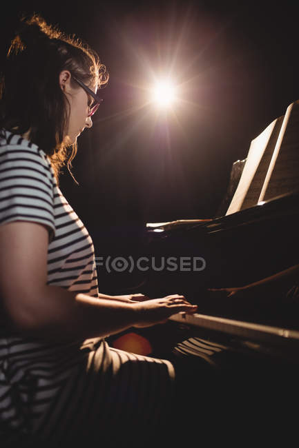 Студентка играет на фортепиано в студии — стоковое фото
