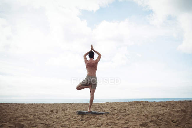 Homem realizando ioga na praia — Fotografia de Stock