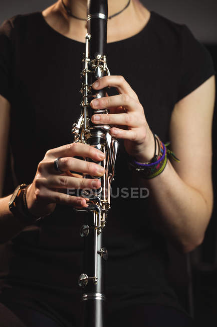 Середній розділ жінки, що грає кларнет у музичній школі — стокове фото