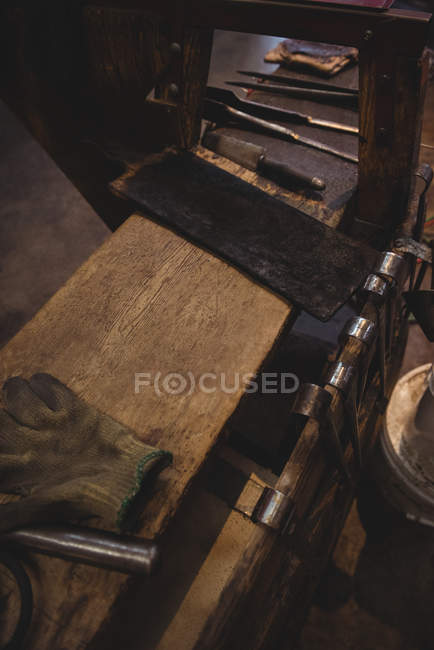 Primer plano de la herramienta de soplado de vidrio en la mesa en la fábrica de soplado de vidrio - foto de stock
