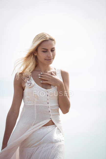 Bela mulher loira em vestido branco andando ao ar livre — Fotografia de Stock