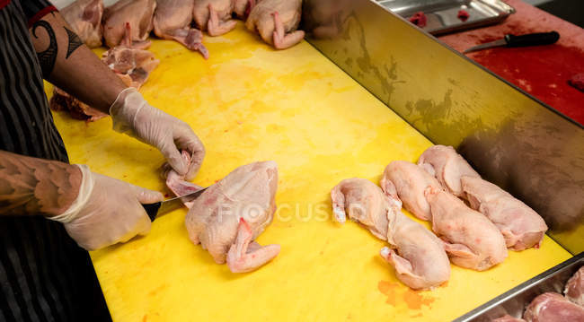 Fleischerhände hacken Hühnchen auf Arbeitstheke in Metzgerei — Stockfoto