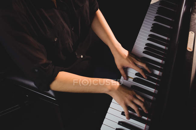 Mid-section of female student playing piano in a studio — Stock Photo
