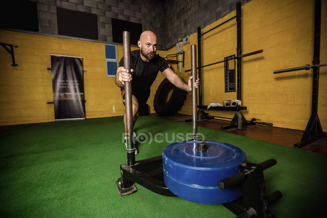 Thai boxer practicing weight exercise in fitness studio — Stock Photo