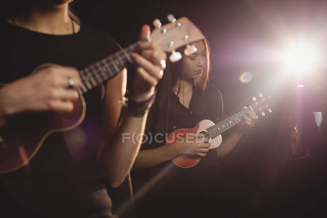 Красивые женщины играют на гитаре в музыкальной школе — стоковое фото
