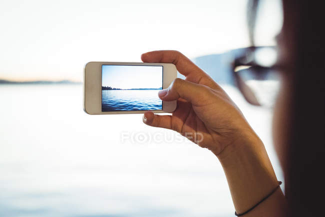 Gros plan de la femme qui prend des photos du paysage urbain sur son téléphone portable — Photo de stock