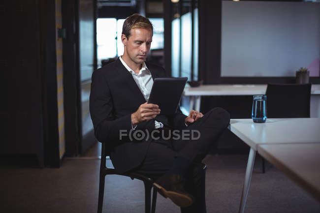 Homem de negócios concentrado usando tablet digital no escritório — Fotografia de Stock