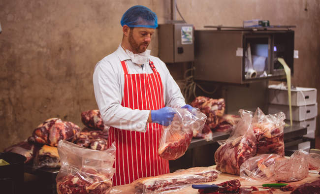 Macellaio imballaggio carne rossa in magazzino presso macelleria — Foto stock