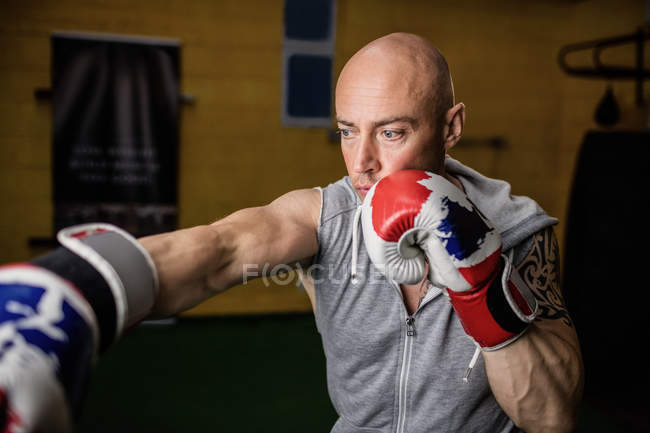 Schöner thailändischer Boxer beim Boxen im Fitnessstudio — Stockfoto