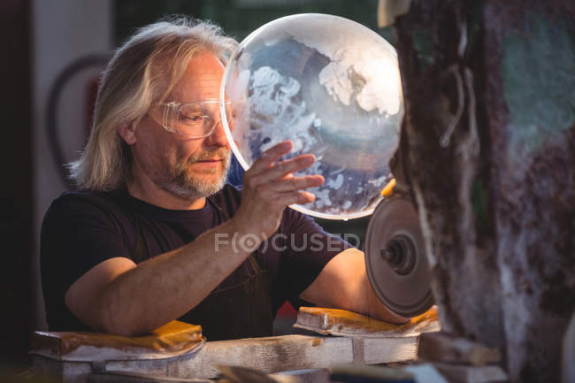 Soplador de vidrio trabajando en un vidrio en la fábrica de soplado de vidrio - foto de stock