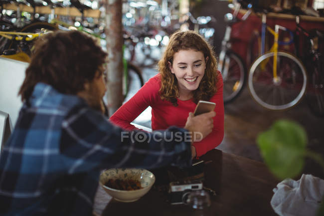 Happy couple using mobile phone in workshop — Stock Photo