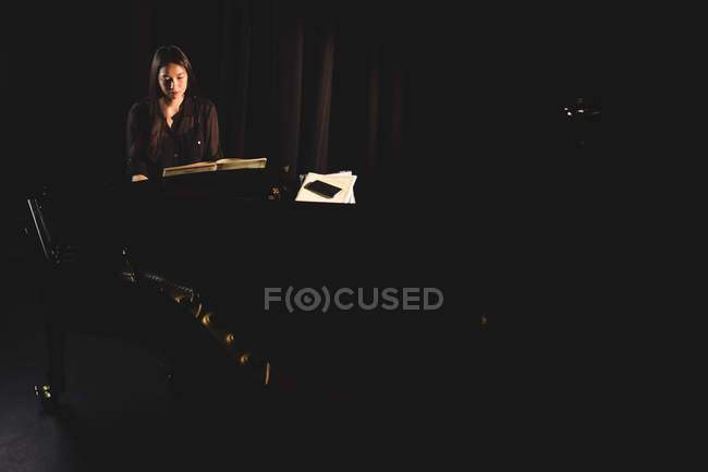 Bella donna che suona un pianoforte in studio di musica — Foto stock