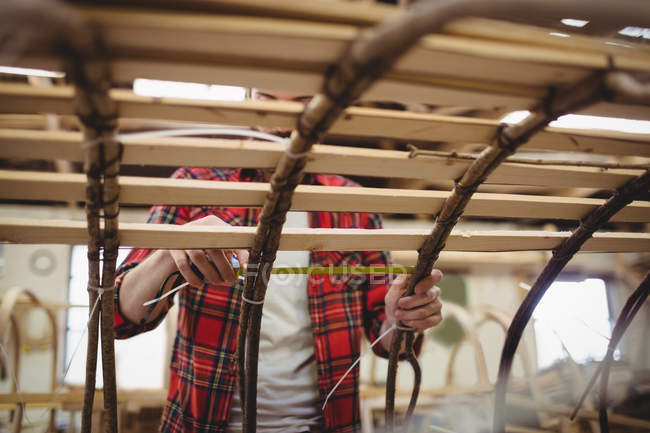 Человек готовит деревянный каркас лодки на верфи — стоковое фото