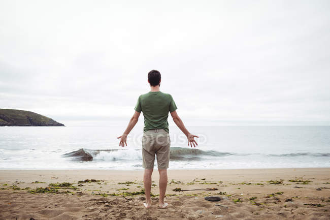 Vista trasera del hombre de pie en la playa - foto de stock