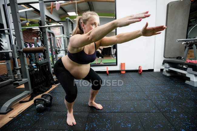 Donna incinta che esegue esercizio di stretching in palestra — Foto stock