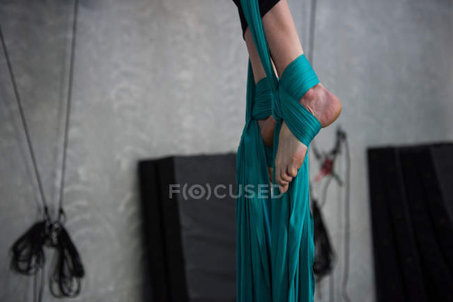 Close-up of gymnast exercising on blue fabric rope in fitness studio — Stock Photo