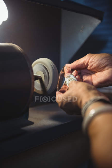 Hands of craftswoman working on a machine in workshop — Stock Photo