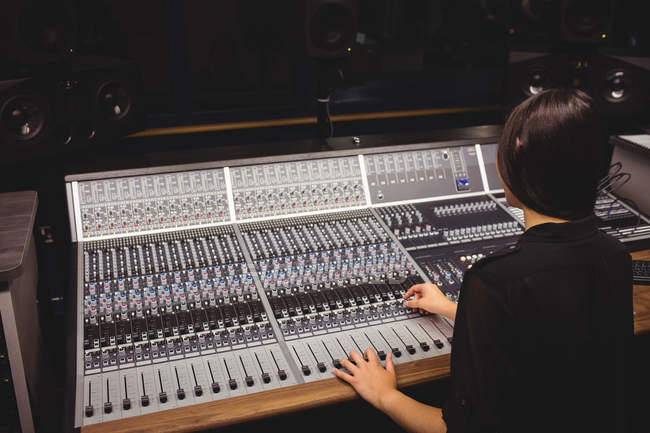 Studente femminile utilizzando mixer audio in uno studio — Foto stock