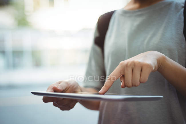 Средняя часть женщины с помощью цифрового планшета на улице — стоковое фото
