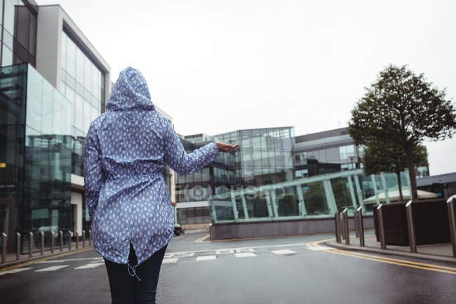 Visão traseira da mulher de pé na rua durante a estação chuvosa — Fotografia de Stock