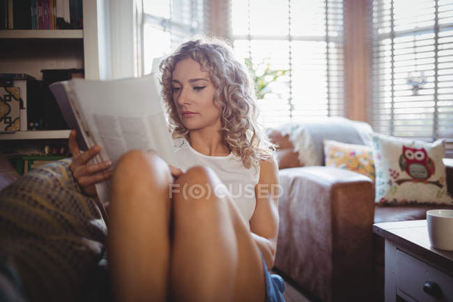 Женщина читает журнал в гостиной дома — стоковое фото