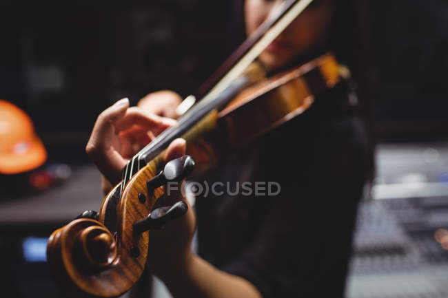 Female student playing violin in a studio — Stock Photo