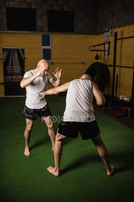 Two kick boxers fighting in gym — Stock Photo
