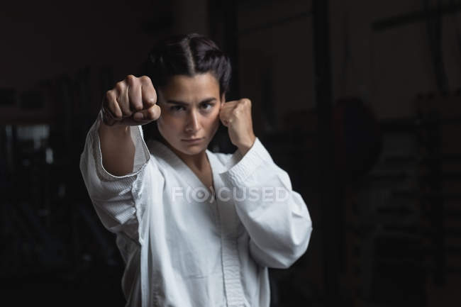 Женщина в кимоно занимается карате в фитнес-студии — стоковое фото