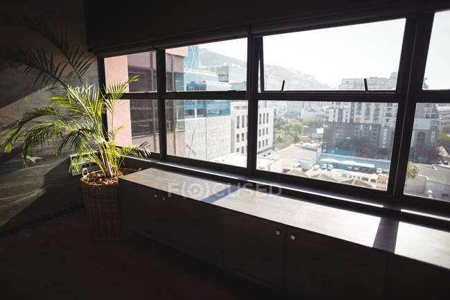 Vue des bâtiments modernes à travers la fenêtre de bureau moderne — Photo de stock