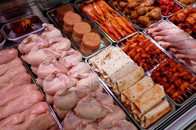 Разнообразие маринованного мяса в мясной лавке — стоковое фото