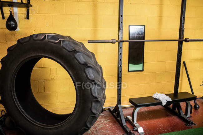 Tire and workout bench in empty fitness studio — Stock Photo