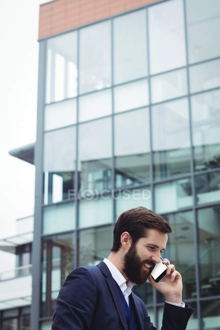 Бизнесмен разговаривает по мобильному телефону за пределами офиса — стоковое фото