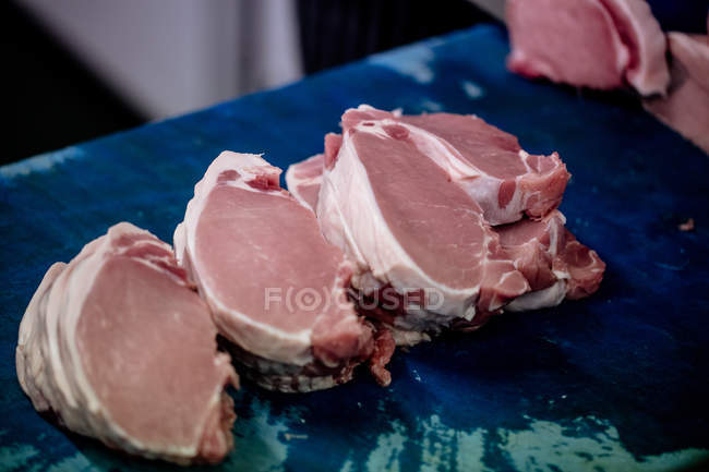 Raw steaks kept on work counter at butchers shop — Stock Photo