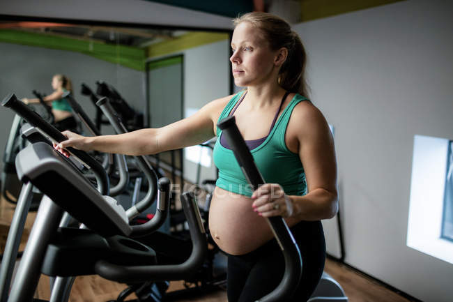 Schwangere trainiert auf Laufband im Fitnessstudio — Stockfoto