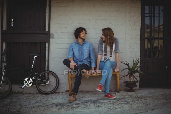 Couple sitting on bench and interacting with each other — Stock Photo