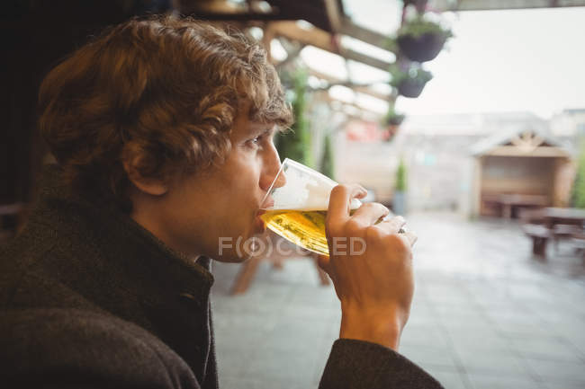 Удумливий чоловік має келих пива в барі — стокове фото